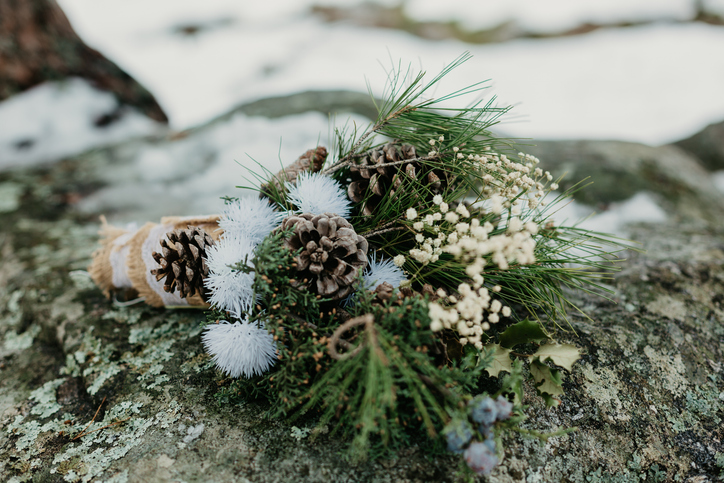 Ramas de pino, piñas, flores secas y blanco invernal. Un bouquet que celebra la belleza serena del frío.